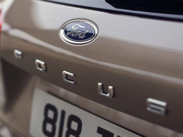 Een close-up van een Ford Kuga-badge op een auto.