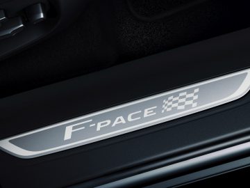 De deurklink van een auto met het woord F-Pace erop.