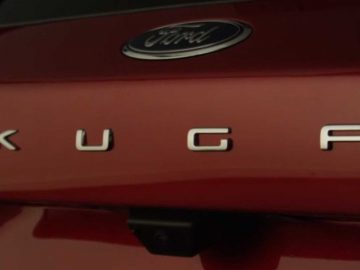 Een close-up van een rode auto met het woord Kuga erop.