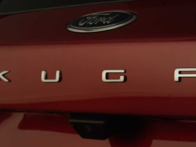 Een close-up van een rode auto met het woord Kuga erop.