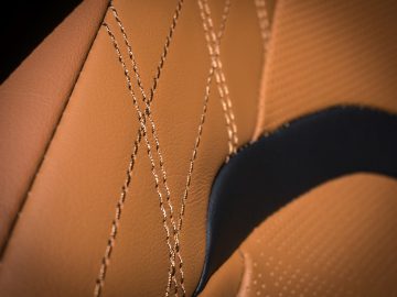 Een close-up van het stiksel op een bruinleren stoel in een Lexus UX.