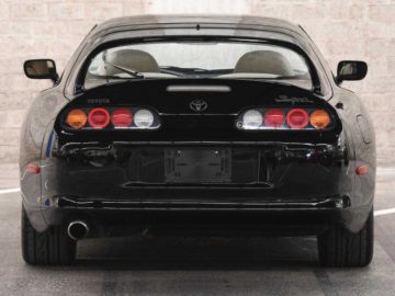 Een zwarte Supra-sportwagen geparkeerd op een parkeerplaats.