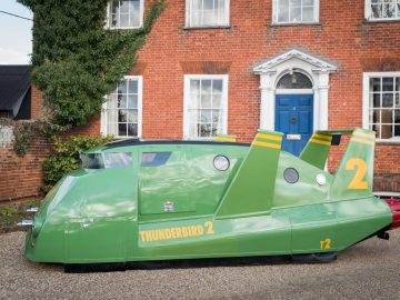 Een groene Thunderbird geparkeerd voor een huis.