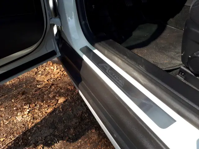 De met vuil bedekte deurgreep van een witte Ford Focus Active.