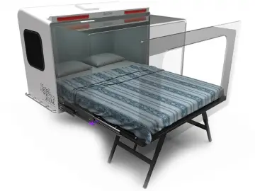 Een bed in een Hitch Hotel-campertrailer met een matras erop.