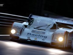 Een Gran Turismo-raceauto die 's nachts over een circuit rijdt.