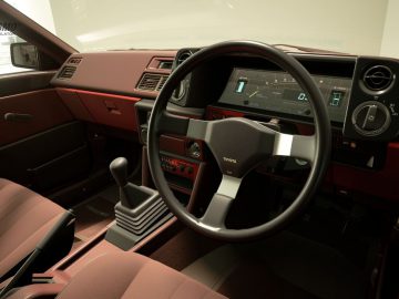 Het interieur van een Gran Turismo-auto met een stuur en dashboard.