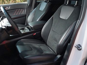 Het interieur van een Ford Edge met zwart lederen stoelen.