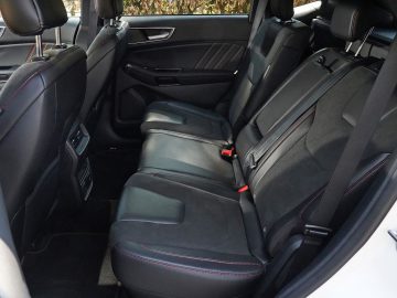 De achterbank van een Ford Edge met zwart lederen stoelen.