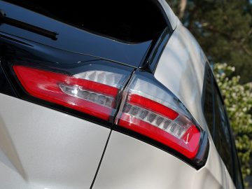 Een close-up van de achterlichten van een witte Ford Edge SUV.