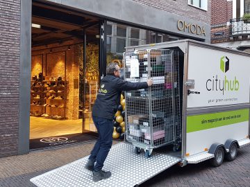 Een man laadt een karretje in een winkel in de City Hub.