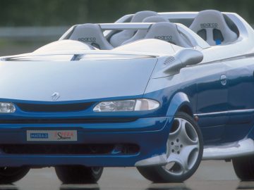 Een blauw-witte Sbarro-cabriolet op een weg.