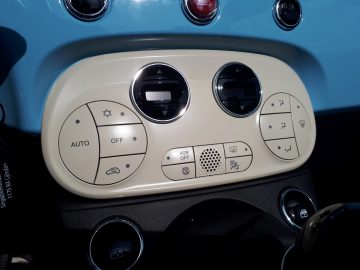 Het dashboard van een blauwe auto 500C Spiaggina '58 met knoppen erop.