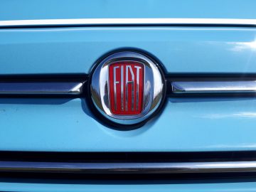 Een close-up van het 500C Spiaggina '58-embleem op een blauwe auto.