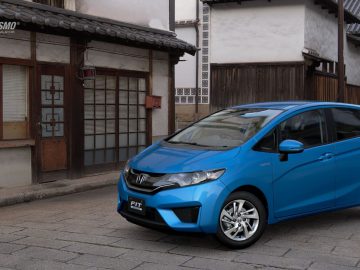 Voor een Japans huis staat een blauwe Honda Fit, die doet denken aan een auto uit Gran Turismo.