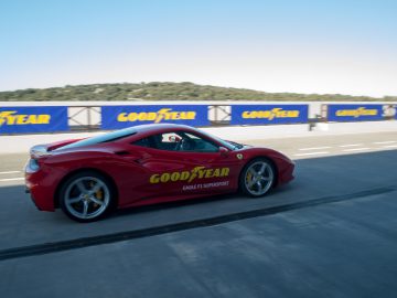 Een rode Ferrari-sportwagen die op een circuit rijdt met Goodyear Eagle F1-banden.