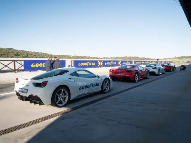 Een groep sportwagens uitgerust met Goodyear Eagle F1-banden geparkeerd op een parkeerplaats.