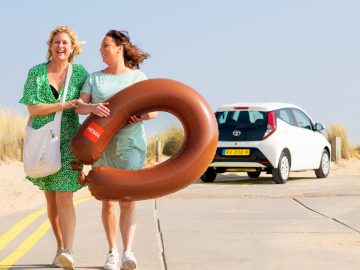 Twee vrouwen lopen over straat met HEMA Private Lease-documenten.
