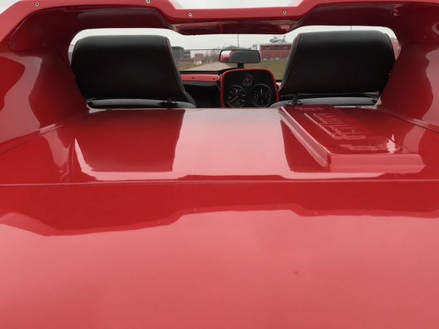 Het achteraanzicht van een rode Isdera-sportwagen.