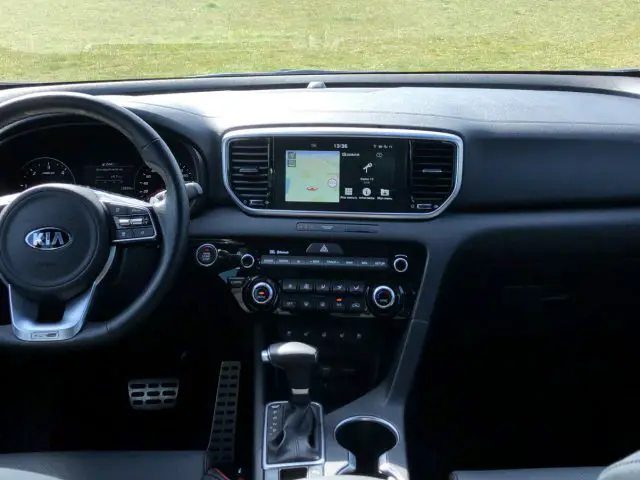 Het interieur van een Kia Sportage met dashboard en stuur.