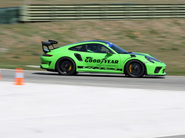 Een groene Porsche GT3 racet op een circuit met Goodyear Eagle F1-banden.