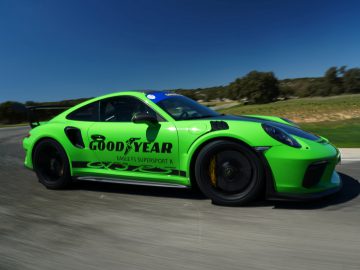 Een groene Porsche GT3 uitgerust met Goodyear Eagle F1-banden die racet op een circuit.