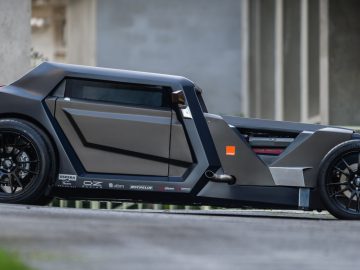 Voor een gebouw staat een futuristische Sbarro-auto geparkeerd.