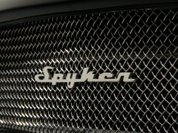 Een close-up van de grille van een zwarte Spyker-auto.