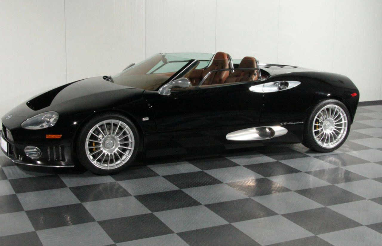 Een Spyker-sportwagen op een geblokte vloer.