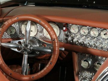 Het interieur van een klassieke Spyker-auto met stuur en dashboard.