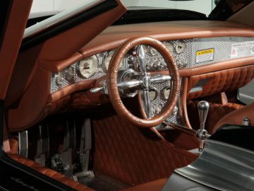 Het interieur van een Spyker-klassieker met lederen stoelen en stuurwiel.