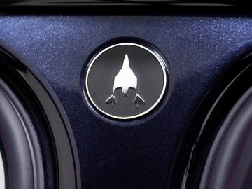 Een close-up van een blauwe Range Rover met een logo erop.