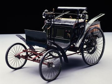 Een zwart-wit afbeelding van een antieke Benz Velocipede-auto.