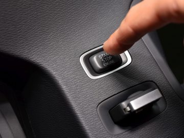 Een persoon drukt op een knop op een autosleutel.