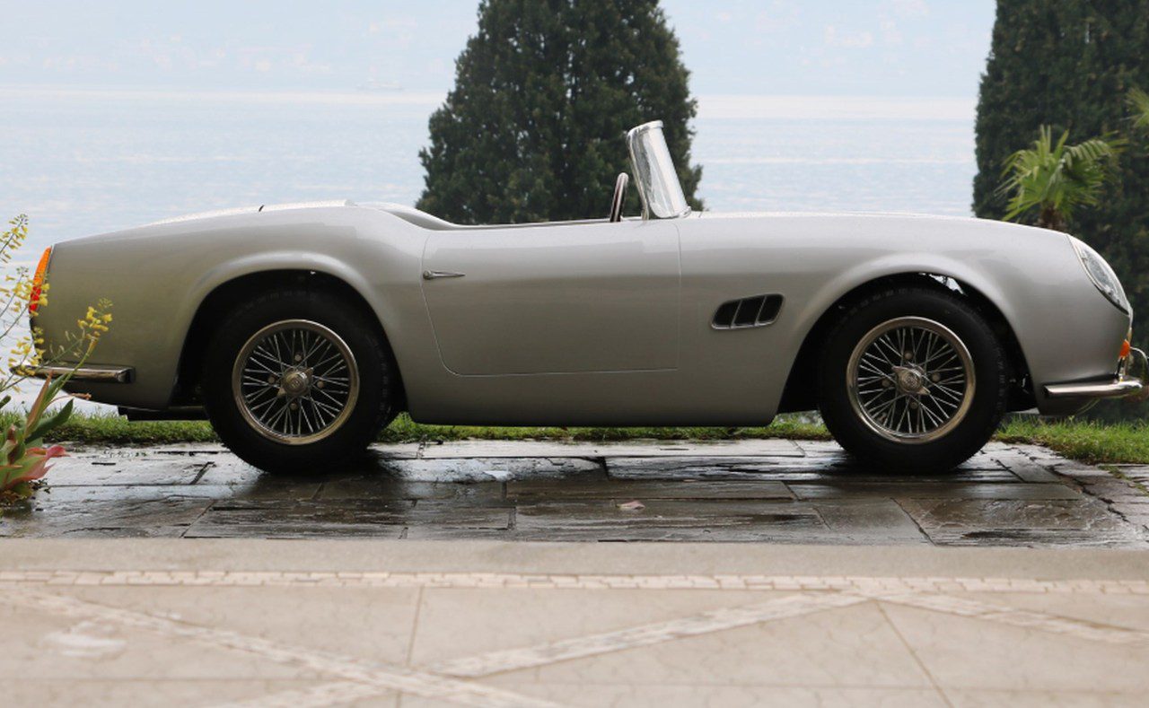 Een zilveren sportwagen geparkeerd voor een meer in Californië.