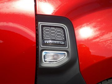 Een close-up van de rode deurklink van een Dacia Duster TCe 130.