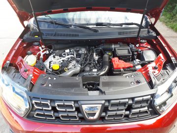 De motorkap van een rode Dacia Duster TCe 130 met rode motor.