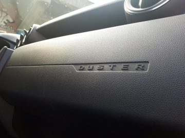 Het dashboard van een Dacia Duster met het woord duster erop.