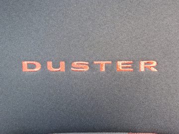 Een close-up van een Dacia Duster TCe 130-tas met het woord "Duster" erop.