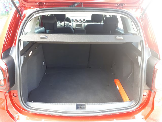 De kofferbak van een rode Dacia Duster TCe 130 is open.