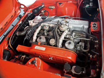 Het motorcompartiment van een rode Benz.