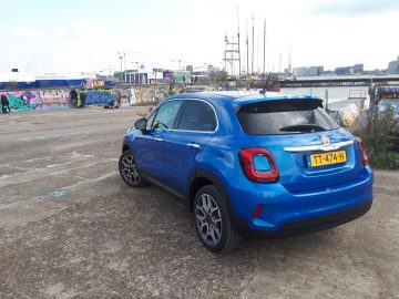 Een blauwe Fiat 500X Opening Edition geparkeerd op een parkeerplaats.
