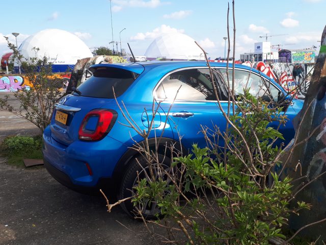 Een blauwe Fiat 500X Opening Edition geparkeerd op een parkeerplaats.
