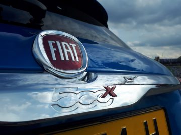 Het embleem van een blauwe Fiat 500X Opening Edition-auto.