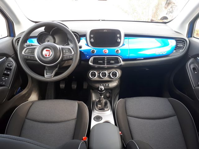 Het interieur van een Fiat 500X Opening Edition met een blauw dashboard en stuur.