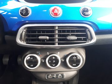 Het dashboard van een Fiat 500X Opening Edition blauwe auto met knoppen erop.