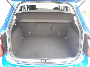 De achterkant van een blauwe Fiat 500X Opening Edition met de kofferbak open.
