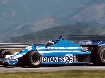 Een Ligier blauwe raceauto op een circuit.