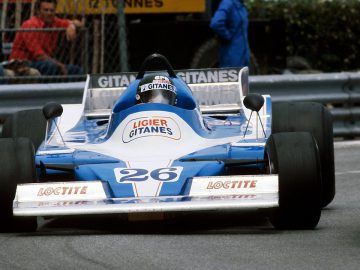 Een blauw-witte Ligier-raceauto op een circuit.