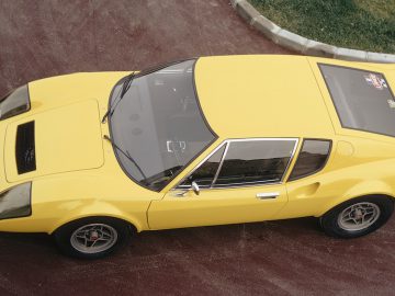 Een gele Ligier-sportwagen staat geparkeerd op een parkeerplaats.